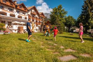 a group of people playing frisbee in a field at Park Hotel Sport in Andalo