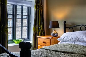 a bedroom with a bed and a window and a lamp at The Bull at Foolow in Hucklow
