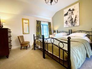 a bedroom with a large bed and a chair at The Bull at Foolow in Hucklow