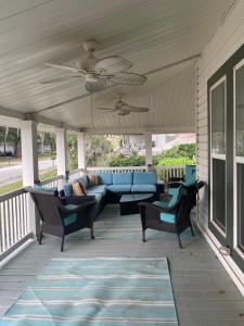un patio con sofá y sillas en un porche en The Rose on Lakeside en Umatilla