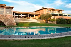 a swimming pool in the yard of a house at Due Lune Puntaldia Resort & Golf in San Teodoro