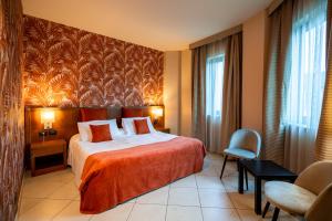 een hotelkamer met een bed en een stoel bij Hotel Parisi in Nichelino