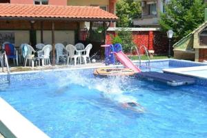 a swimming pool with a slide in the water at Къща за гости Бор in Pomorie