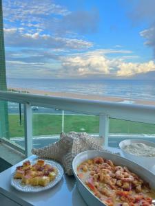 a table with two dishes of food on a balcony at Brisa da praia ao lado Centro de Convenções in Salvador