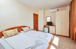 a bedroom with a large bed and a television at Къща за гости Бор in Pomorie