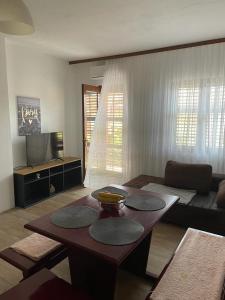 a living room with a table and a couch at Apartman Adriatic BnM in Biograd na Moru