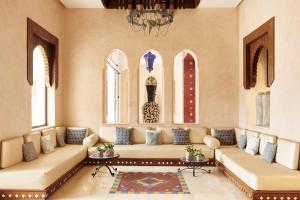 Iberostar Founty Beach All Inclusive في أغادير: غرفة معيشة مع أريكة كبيرة ونوافذ
