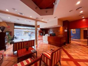 a lobby with chairs and a bar in a store at Hotel Vila de Tossa in Tossa de Mar