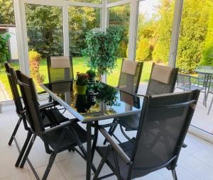 a dining room with a glass table and chairs at Tóparti Apartmanház in Balatonszárszó