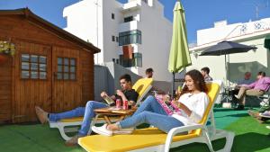 eine Gruppe von Menschen, die an einem Tisch auf einer Terrasse sitzen in der Unterkunft Guest House Sao Filipe in Faro