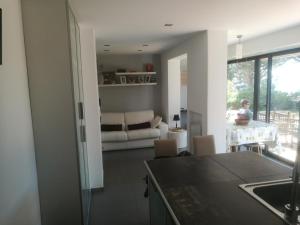 een keuken en een woonkamer met een tafel en een bank bij appartement avec jardin vue sur mer 2 étoiles in Cassis