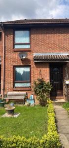 a brick house with a window and a grass yard at LONDON 1 BED COSY HOUSE in Norwood