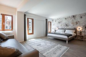 a bedroom with a bed and a couch at Palace Canal View by Wonderful Italy in Venice