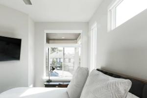 a white bedroom with a bed and a window at Capitol View Condos by One Fine Bnb - Paramount in Austin