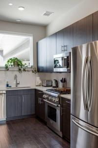 a kitchen with a stainless steel refrigerator and wooden cabinets at Capitol View Condos by One Fine Bnb - Paramount in Austin