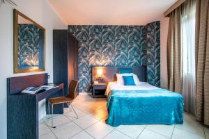 una camera d'albergo con letto, tavolo e sedia di Hotel Parisi a Nichelino