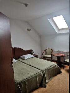 1 dormitorio con cama, mesa y ventana en Pensiunea Belladonna Baile Olanesti en Băile Olăneşti