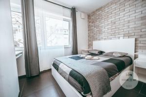 - une chambre avec un lit et un mur en briques dans l'établissement WakeUp Esch-City, à Esch-sur-Alzette