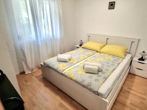 Apartment Deni في Skrbčići: غرفة نوم مع سرير مع ورود صفراء عليه