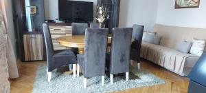 einem Esstisch mit schwarzen Stühlen und einem Sofa in der Unterkunft Apartman ,,Milica'' in Donji Milanovac