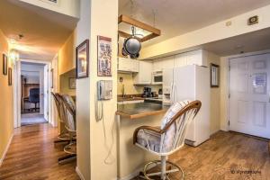 a kitchen with three bar stools and a counter top at ON THE STRIP - Classic Comfort - 2 Bedroom Condo in Las Vegas