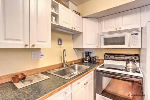 a kitchen with white cabinets and a sink at ON THE STRIP - Classic Comfort - 2 Bedroom Condo in Las Vegas