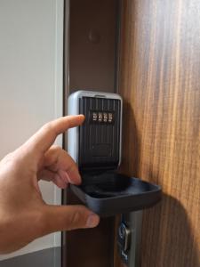 a persons hand pointing at a card inserted into a door at Funcional Condo- Kraków bezpłatne miejsce w garażu in Krakow