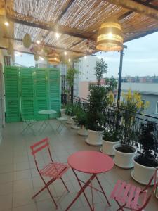un patio con sillas y mesas rojas y persianas verdes en ATTICO 59, en Bisceglie