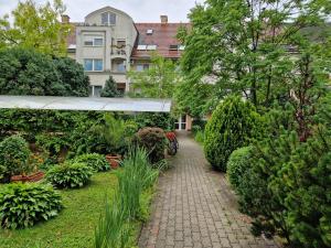 un jardín con una pasarela frente a un edificio en Márti 3 Bedroom Apartment, en Debrecen