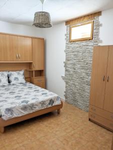 1 dormitorio con cama y pared de ladrillo en Appartement Saint Jean 2 Cosy et Confort, en Villefranche-de-Conflent