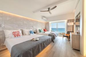 Dos camas en una habitación de hotel con el océano en Pestana Blue Alvor Beach - All Inclusive Hotel, en Alvor