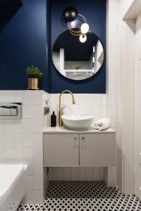 een badkamer met een wastafel en een spiegel bij Polka Apartment in Krakau