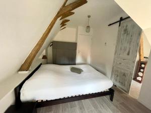 una camera da letto con letto bianco in mansarda di Appartement cosy vue sur le vignoble a Sancerre