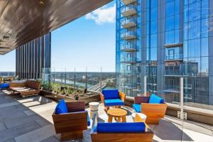 a balcony with chairs and tables on a building at Luxury 1BR - Rainey St - Top Amenities - RoofTop Pool - 11th Floor in Austin