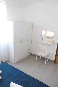 een witte kamer met een stoel en een bureau bij Apartment Nia&Nika Caska, Novalja with sea view and terrace in #N/A