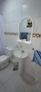 een badkamer met een wastafel, een toilet en een spiegel bij Apartamento Romian in Paysandú