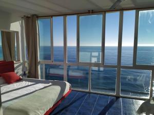 a bedroom with a bed and a view of the ocean at Beachfront apartment in Estepona