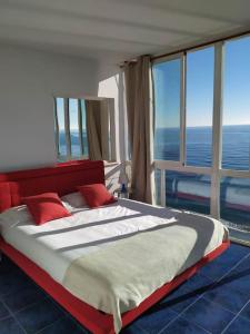 a bedroom with a large bed in a room with windows at Beachfront apartment in Estepona