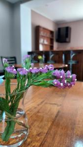 a vase filled with purple flowers sitting on a table at Hotel Max Comfort in Kutaisi