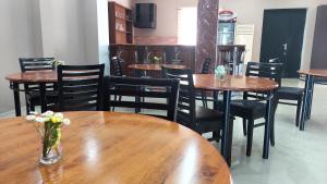a restaurant with wooden tables and chairs with flowers on them at Hotel Max Comfort in Kutaisi
