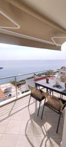 uma varanda com uma mesa e vista para o oceano em Anna Maria Apartment em Skala Marion