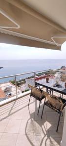 a balcony with a table and a view of the ocean at Anna Maria Apartment in Skala Marion