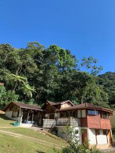 雷森迪德馬烏阿的住宿－CasaMauá，山丘上树木背景的房子