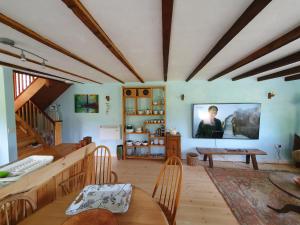 sala de estar con mesa y TV en la pared en Driftwood Cottage, en Yelverton