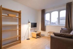 a living room with a couch and a television at 1BD Flat - Prime Location Surrey Quays in London