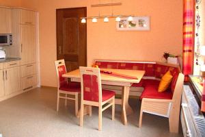 een keuken met een houten tafel en stoelen en een tafel en een stoeltje bij Ferienhof Zum Rössberg in Geisa
