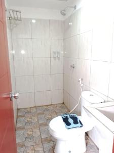 a bathroom with a white toilet and a sink and a toilet at The Aurora by Makati in Lembang