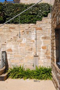 a stone wall with a set of stairs with plants at Le Churchill Hôtel & Spa in Carnac