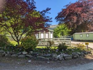 a garden with flowers in front of a house at 55 Glenfinart Caravan Park in Dunoon