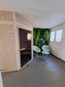 een kamer met 2 stoelen en een tafel. bij Le Churchill Hôtel & Spa in Carnac